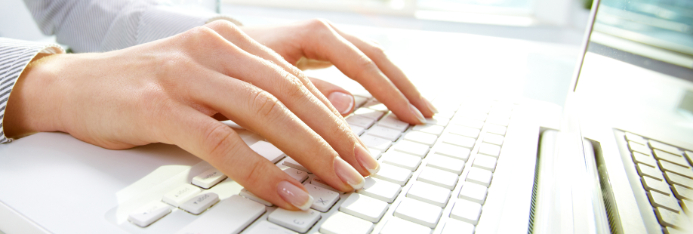woman's hands typing on white keyboard